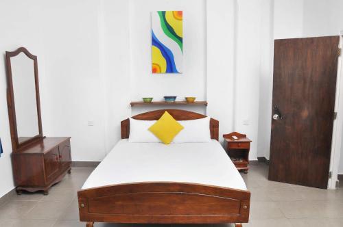 科伦坡Sea View Hotel的一间卧室配有一张黄色星的木床