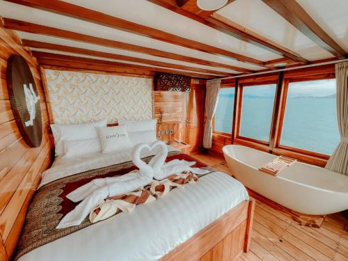 纳闽巴霍Dav-Venture的一间带浴缸和船上天鹅的卧室