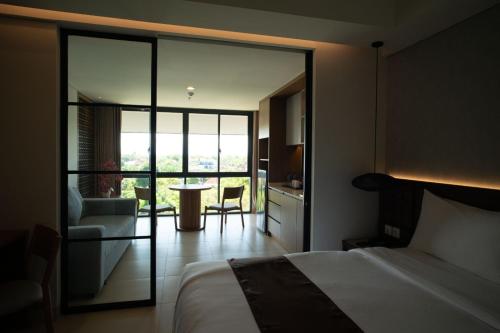 努沙杜瓦Lavaya Resort Nusa Dua Bali的一间卧室配有一张床铺和一张桌子,还设有一间厨房
