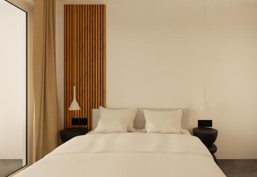帕拉马Pontikonisi Hotel & Suites的卧室配有一张带两把椅子的白色大床