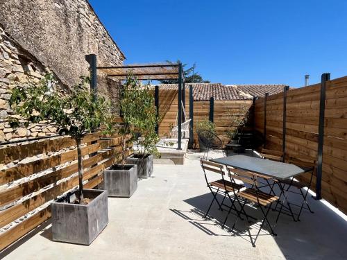Saint-GervasyAppartement cosy avec terrasse的一个带桌椅的庭院,毗邻墙壁