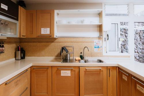 阿德耶Endless Summer Hostel的一个带木制橱柜和水槽的厨房