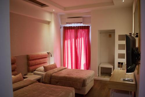 雅典雅典弥诺阿酒店的一间设有两张床和红色窗帘的房间