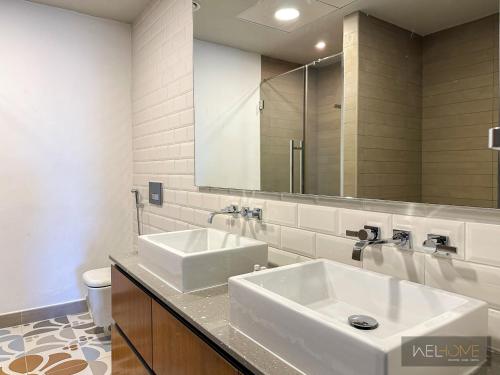 迪拜WelHome - Prime 1BR Apartment at Oia Residence的浴室设有2个水槽和镜子