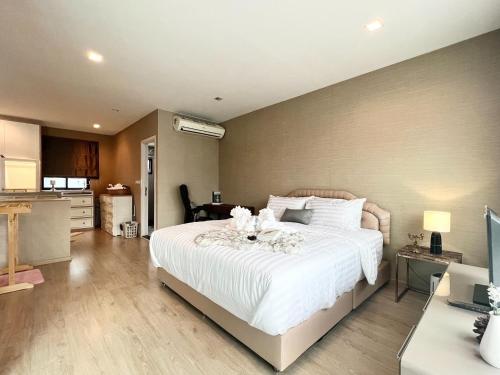 曼谷Free pick up / Stunning Luxury Family Home 3B3B的一间卧室配有一张白色大床,床上有鲜花