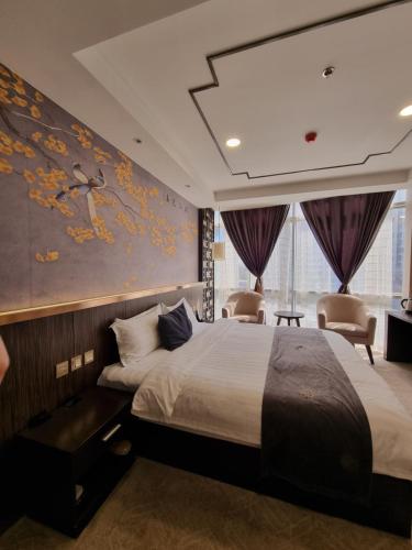 杜尚别Friendship HOTEL的酒店客房,设有一张床铺和一幅画作的墙壁