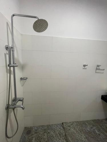 ButtalaHotel Eco Garden的浴室铺有白色瓷砖,设有淋浴。