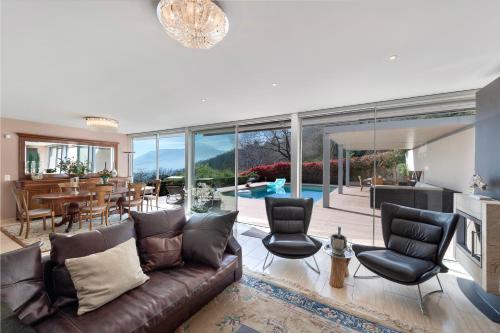 卢加诺Villa Dolce Vita With Private Pool - Happy Rentals的客厅配有棕色真皮沙发和椅子