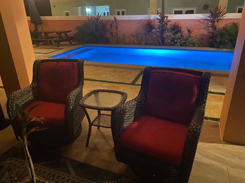 拿骚Island Breeze Guest Suite的两把椅子和一张桌子以及一个游泳池
