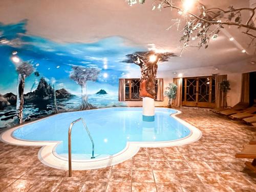 阿尔滕马克特蓬高乌尔比斯古特酒店的一间房间内的热水浴缸,上面有一幅树画