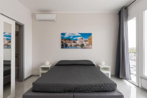 钱皮诺Travelershome Ciampino Airport GuestHouse的白色卧室配有一张床,墙上挂着一幅画