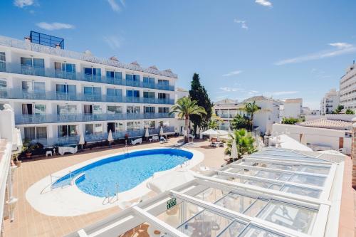 内尔哈Hotel Villa Flamenca的享有酒店、游泳池和大楼的景色