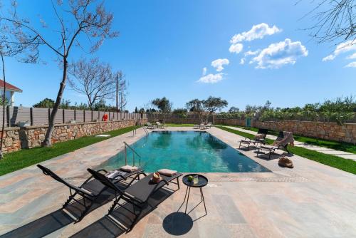 科林比亚Serenity Villas的一座带躺椅的游泳池,毗邻石墙