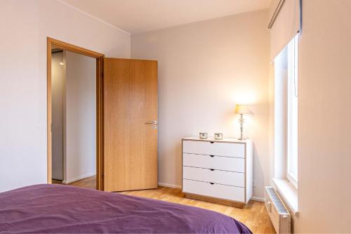 派尔努Aida 7 Apartment的一间卧室配有一张床、一个梳妆台和一扇窗户。