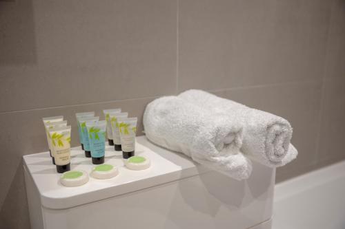 泰晤士河畔金斯顿Charming One-Bedroom Retreat in Kingston KT2, London的浴室提供毛巾和带牙刷的架子