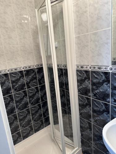 香侬Cosy Room的浴室铺有黑白瓷砖,设有淋浴。