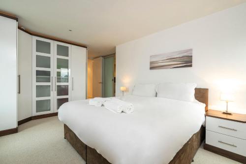 伦敦Borough Flat with City Views by UnderTheDoormat的卧室配有带毛巾的大型白色床