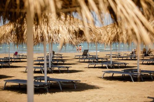 巴库Sea Breeze Resort, Lighthouse2 seaside studio apartment的海滩上的一组椅子和遮阳伞