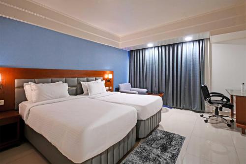 海得拉巴Palette - Madhapur的酒店客房设有一张大床和一张书桌。