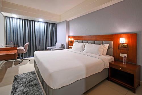 海得拉巴Palette - Madhapur的酒店客房设有一张大床和一张书桌。