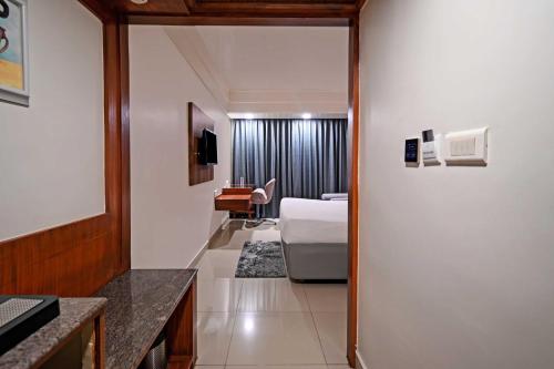 海得拉巴Palette - Madhapur的配有一张床和一张书桌的酒店客房