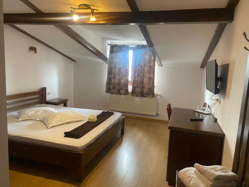 奥内什蒂La Strada的一间卧室配有一张床、一张桌子和一个窗户。