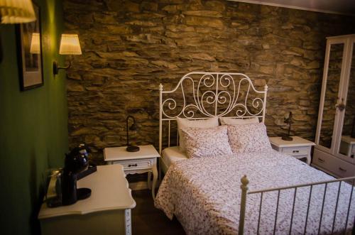 拉罗什-阿登B&B Au Canard的一间卧室设有一张床和石墙