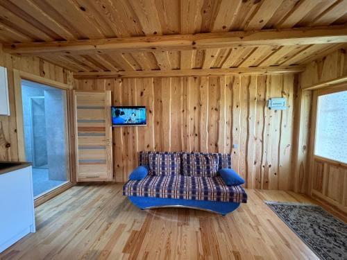 Varniškės IStripeikių Bitė的客厅配有沙发,客厅设有木墙