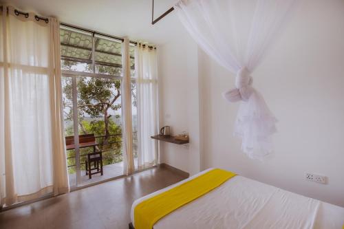 贝里胡罗亚Treehouse Chalets的一间卧室设有一张床和一个大窗户