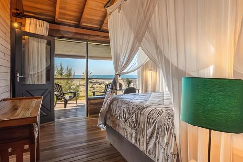 伊比拉奎拉Villa Sayuri的一间卧室配有一张床,享有海景