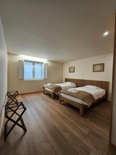 米兰达·杜·杜罗BUTEKO HOUSE AL的客房内设有两张床,铺有木地板,设有窗户。