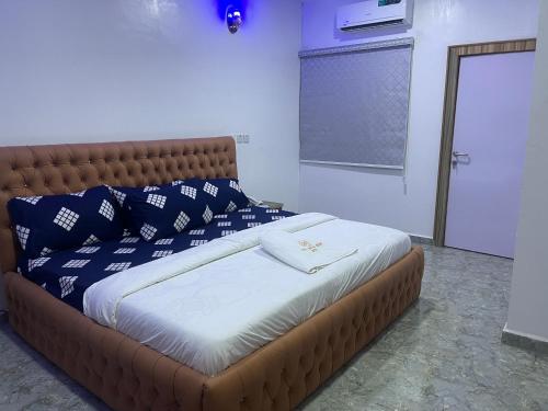 MakurduFirst Royal Beam Hotel的一张带蓝色和白色枕头的床