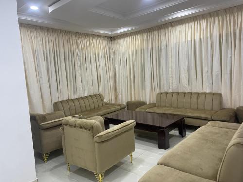 MakurduFirst Royal Beam Hotel的带沙发、桌子和窗帘的客厅