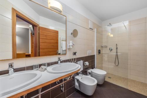 莱德罗阿德里安娜家庭旅馆的一间带水槽、卫生间和镜子的浴室