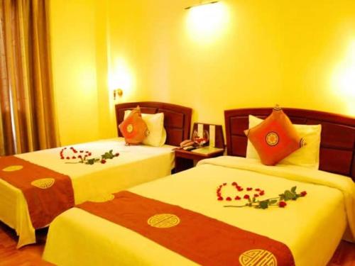 Sóc SơnNhà nghỉ Vĩnh Phát Nội Bài的酒店客房,配有两张带鲜花的床