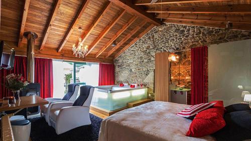 Brion de Arriba卡萨多组勒若乡村民宿的一间卧室设有一张大床和一个浴缸