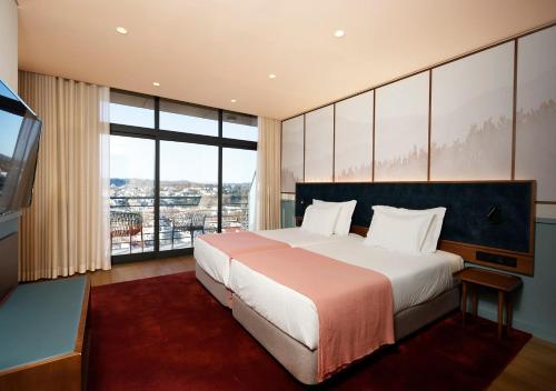 维塞乌维塞乌蒙特贝洛国会酒店的一间卧室设有一张大床和一个大窗户