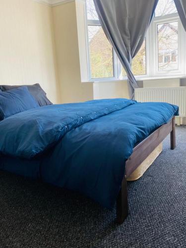 莱斯特Instant Lodge的卧室内的一张蓝色的床,卧室设有窗户
