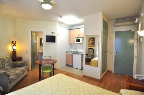 拉拉斯特里拉阿罗索蒂略公寓式酒店的客厅以及带沙发和桌子的厨房。