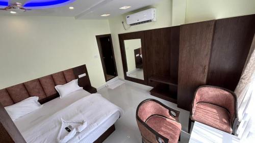 曼达莫尼ELITE MANDARMONI的一间卧室配有一张床和两把椅子