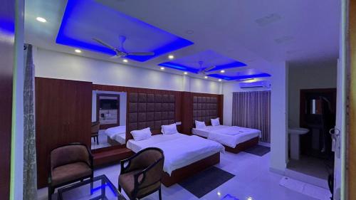曼达莫尼ELITE MANDARMONI的一间卧室设有两张床,天花板上灯亮蓝色。