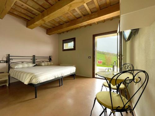 OstraCasale dei Cinque Colli的一间卧室配有一张床、一张桌子和一个窗户。