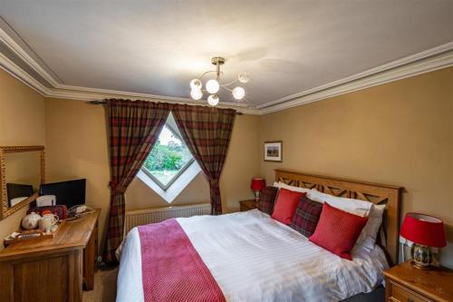 彭里斯白朗特伍德酒店的一间卧室配有一张带红色枕头的床和一扇窗户