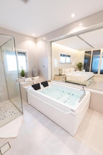 杜拉特阿拉尔Tiffany Beach的大型白色浴室设有大型浸泡浴缸