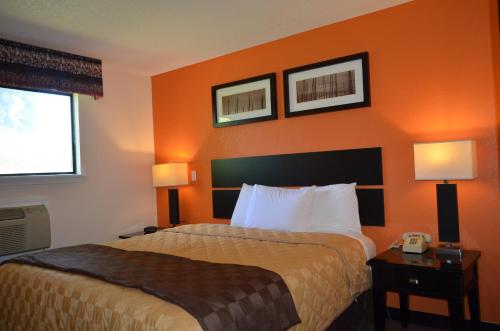 恩菲尔德恩菲尔德酒店的酒店客房,配有一张橙色墙壁的床