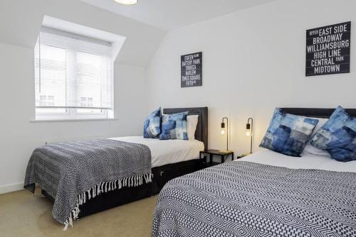 布里奇沃特K Suites - Shetland Court的一间卧室设有两张床和窗户。