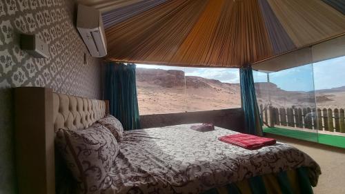 瓦迪拉姆Sultan Luxury Camp的一间卧室配有一张床,享有沙漠美景