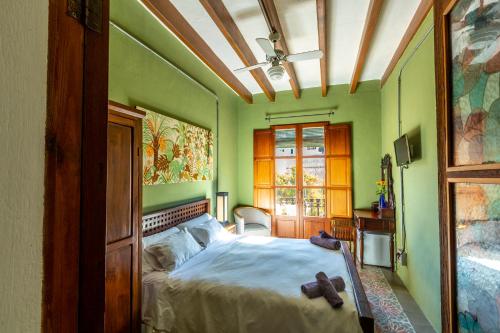 伊维萨镇Ibiza Boutique Guest House的一间卧室设有绿色的墙壁,床上配有泰迪熊