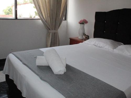 内瓦HOTEL DINASTIA REAL NEIVA的一张白色的床,上面有一张纸条