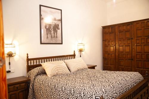 El OjueloVivienda Rural Casa Tavara的卧室配有一张床,墙上挂着一幅画
